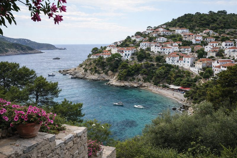 Uitzicht over een rustige baai en heuveldorp op Alonissos met helderblauwe zee en groene heuvels in Griekenland